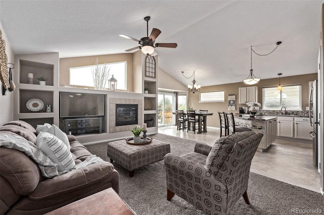 living room with ceiling fan, a fireplace, plenty of natural light, and high vaulted ceiling