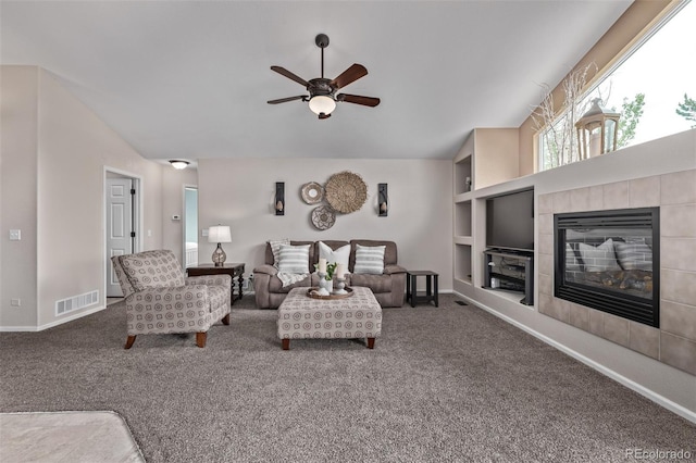 carpeted living room with ceiling fan, baseboards, a fireplace, and built in features