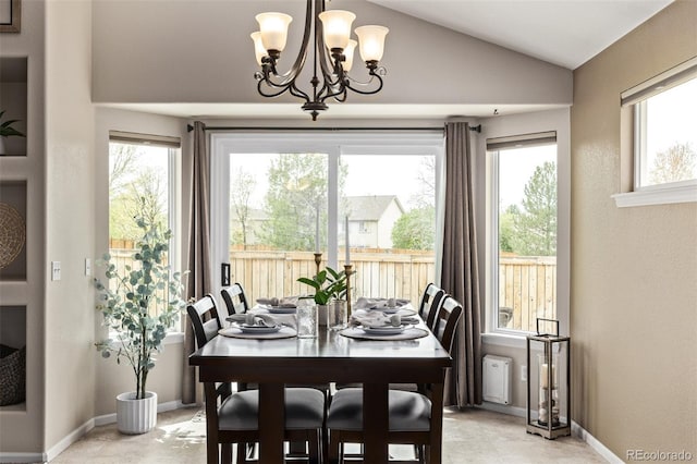 dining area featuring lofted ceiling, a chandelier, and baseboards