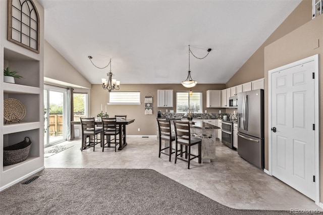 dining space featuring vaulted ceiling, a chandelier, and baseboards