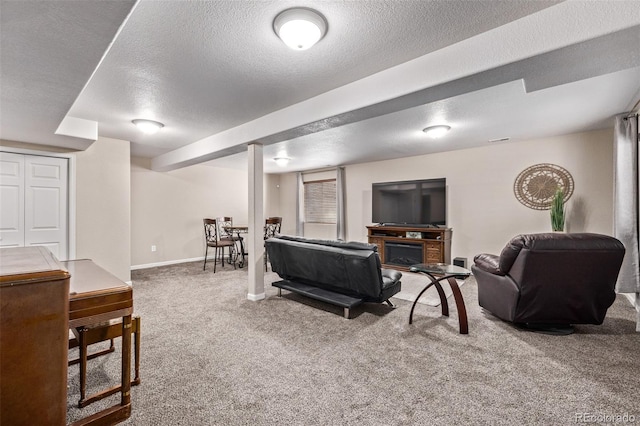 carpeted living area with a textured ceiling and baseboards