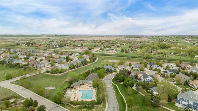 aerial view of property's location featuring a pool area and nearby suburban area