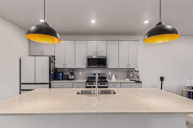 1918 W 165th Way, Broomfield, CO 80023 - kitchen featuring appliances with stainless steel finishes, tasteful backsplash, an island with sink, recessed lighting, and light stone counters
