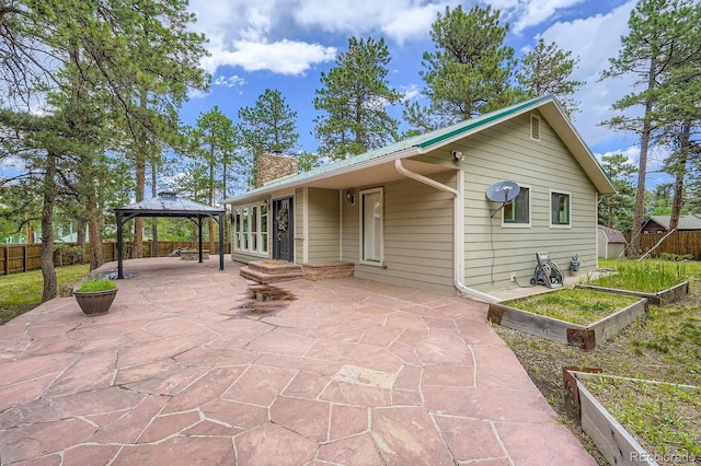 26732 Main St, Conifer, CO 80433 - rear view of house featuring a patio, a gazebo, and a chimney
