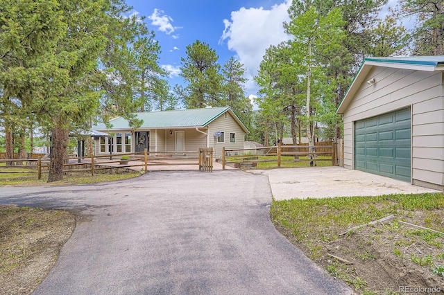 26732 Main St, Conifer, CO 80433 - ranch-style home with asphalt driveway, a porch, and a metal roof