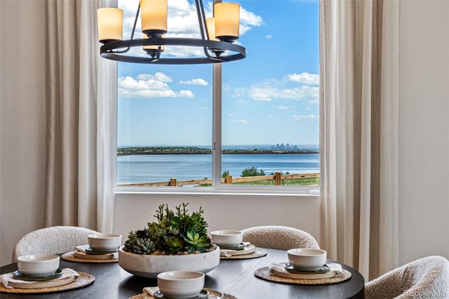 dining room featuring a water view and a chandelier