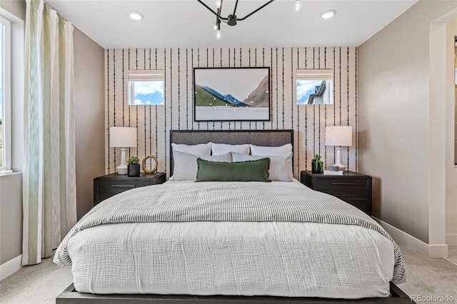 bedroom featuring light carpet and an inviting chandelier