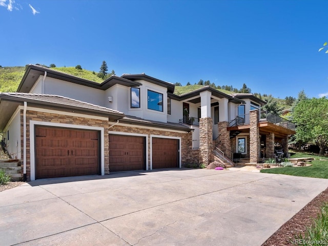 6405 Warriors Run, Littleton, CO 80125 - view of front of home featuring stone siding, stucco siding, concrete driveway, and a garage