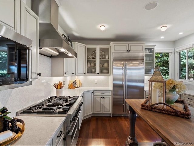 6405 Warriors Run, Littleton, CO 80125 - kitchen featuring high quality appliances, wall chimney exhaust hood, dark wood-style flooring, light countertops, and recessed lighting