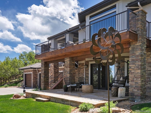6405 Warriors Run, Littleton, CO 80125 - back of property with a balcony, concrete driveway, an attached garage, stairway, and a patio