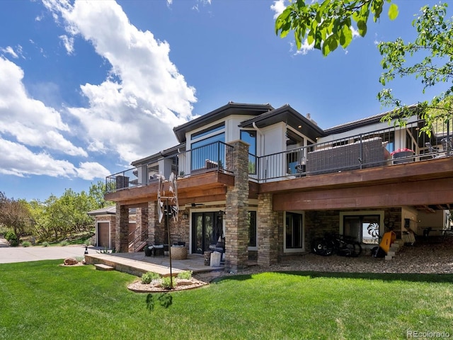 6405 Warriors Run, Littleton, CO 80125 - rear view of house with a balcony, a yard, a patio, stone siding, and driveway