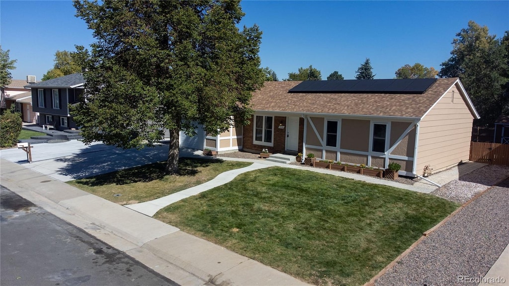 view of front of property featuring a front lawn, solar panels, and a porch