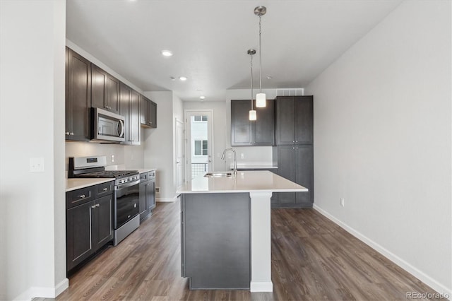 451 Interlocken Blvd Unit 104, Broomfield, CO 80021 - kitchen with stainless steel appliances, a sink, light countertops, dark wood-type flooring, and baseboards