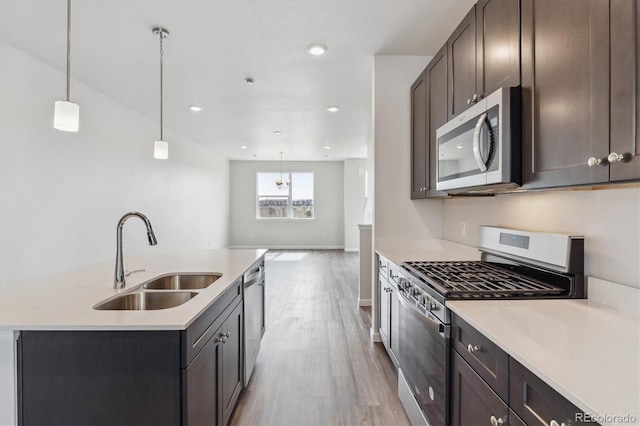 451 Interlocken Blvd Unit 104, Broomfield, CO 80021 - kitchen with stainless steel appliances, a sink, light wood finished floors, dark brown cabinets, and light countertops