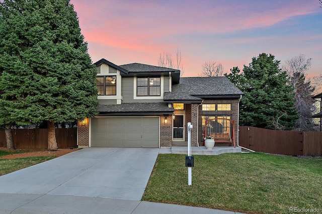traditional home with a front yard, an attached garage, fence, brick siding, and driveway