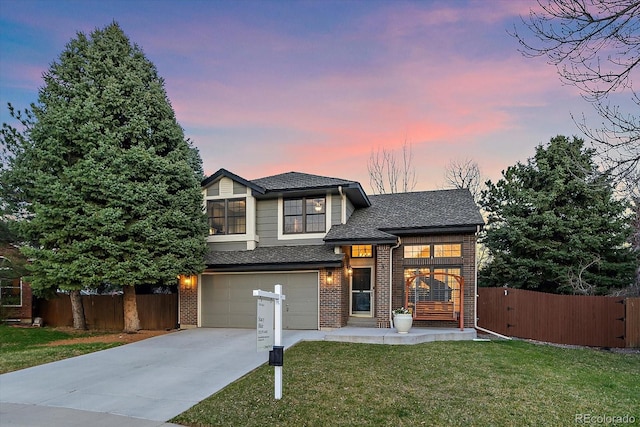 traditional-style house featuring an attached garage, fence, a front lawn, and brick siding