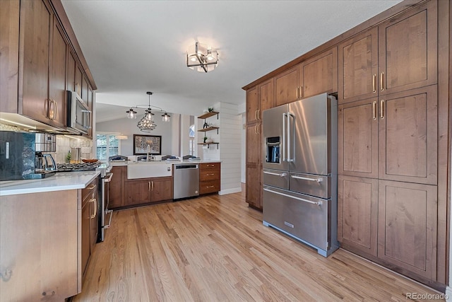 kitchen with light countertops, light wood finished floors, a sink, and stainless steel appliances