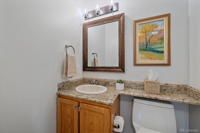 half bathroom with vanity and toilet
