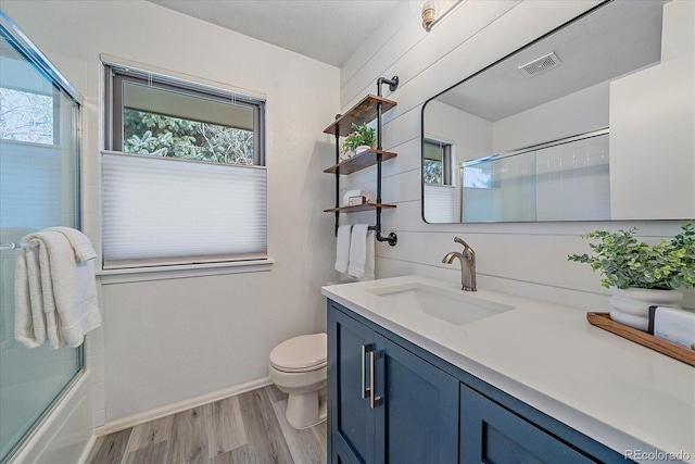 full bathroom featuring visible vents, toilet, plenty of natural light, and wood finished floors