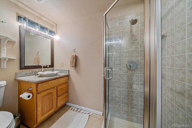 bathroom featuring a shower stall, tile patterned floors, vanity, and toilet