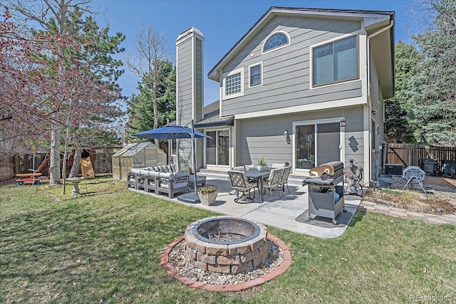 back of property featuring a chimney, a fenced backyard, a patio area, and a lawn