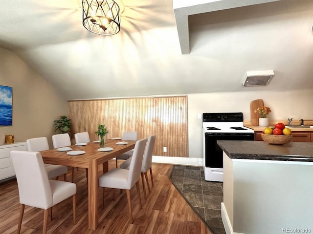 dining room featuring a notable chandelier, lofted ceiling, and dark wood-type flooring