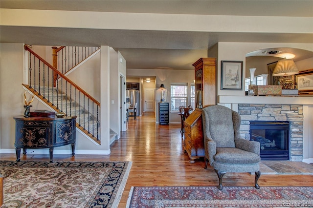 living room with a fireplace and wood-type flooring