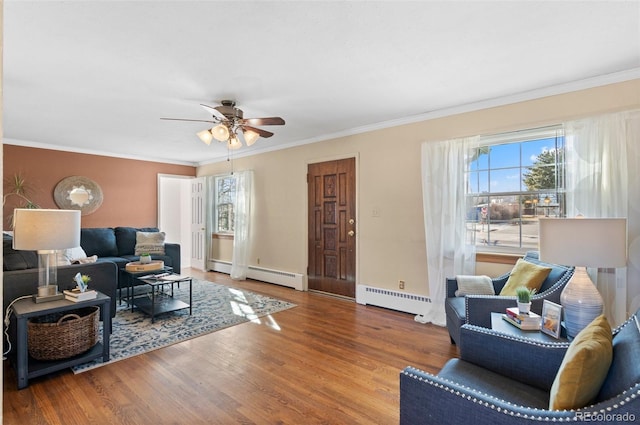 living room with crown molding, a baseboard heating unit, and hardwood / wood-style flooring