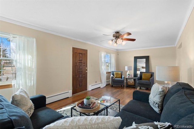 living room with hardwood / wood-style flooring, a baseboard radiator, ceiling fan, and crown molding