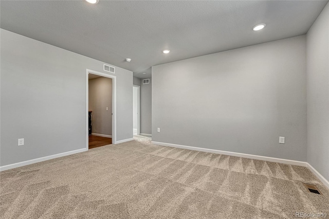 unfurnished room with carpet floors, recessed lighting, visible vents, and baseboards