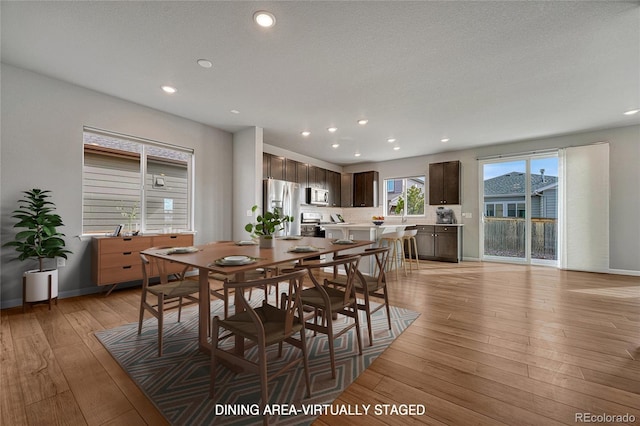 dining room with light wood-style flooring, baseboards, and recessed lighting