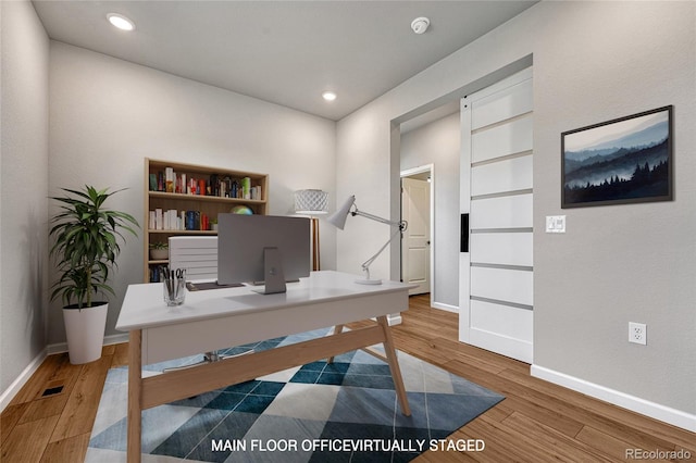 home office with built in features, light wood finished floors, baseboards, visible vents, and recessed lighting