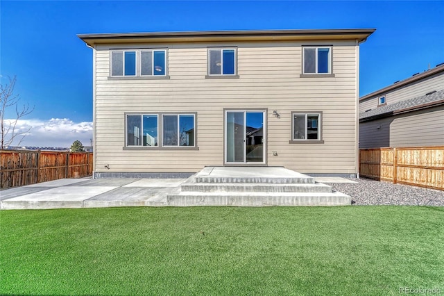 rear view of house featuring a yard, a fenced backyard, and a patio