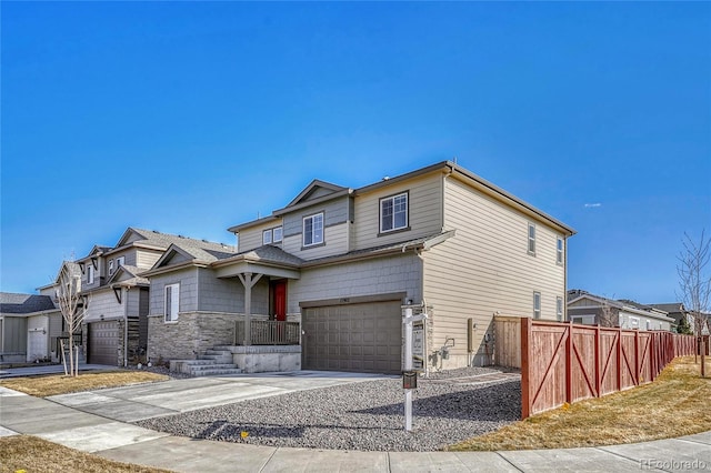 view of front of property featuring a garage, driveway, and fence
