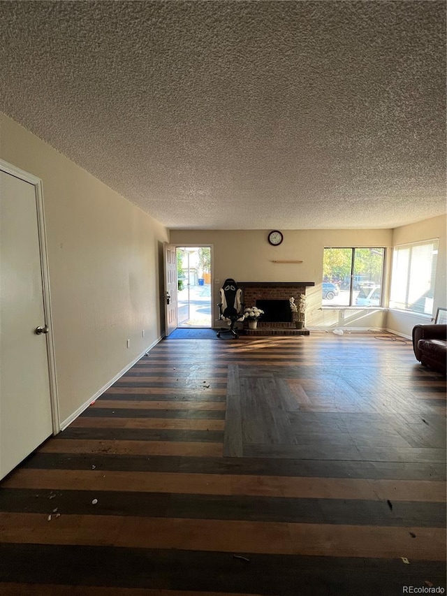 hall featuring dark hardwood / wood-style flooring, a wealth of natural light, and a textured ceiling