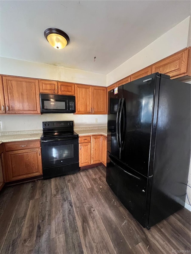 kitchen featuring dark wood-type flooring and black appliances