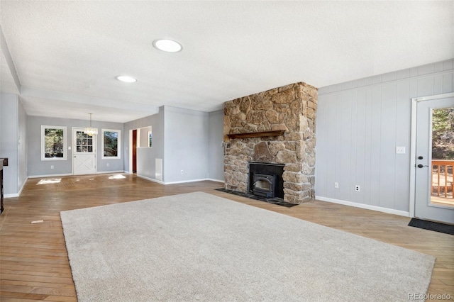 4835 Abo Ln, Monument, CO 80132 - unfurnished living room with baseboards, wood finished floors, a textured ceiling, and a wood stove
