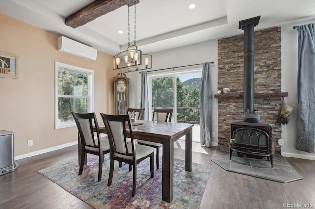 dining room featuring dark hardwood / wood-style flooring, a wall mounted AC, and a wood stove