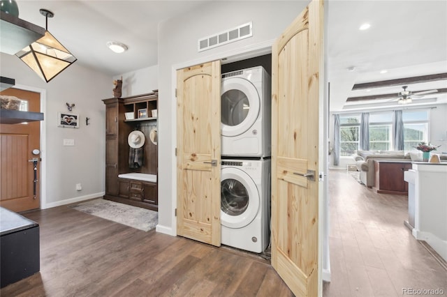 laundry area featuring dark wood-type flooring, ceiling fan, and stacked washer and clothes dryer