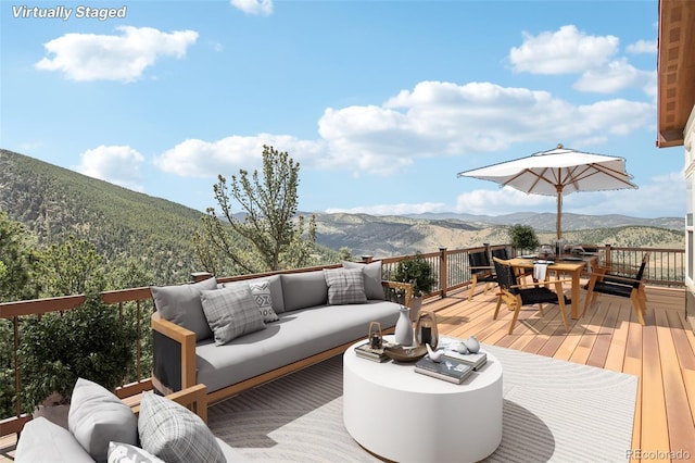 wooden deck featuring a mountain view and an outdoor living space