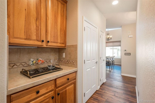 kitchen with an inviting chandelier, backsplash, and dark hardwood / wood-style flooring