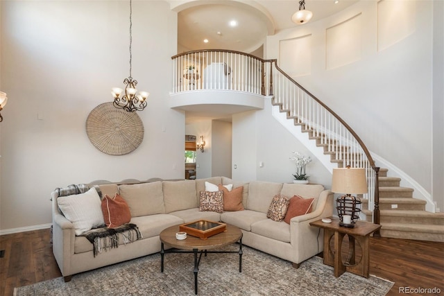 living room featuring a high ceiling, dark wood-type flooring, and a chandelier