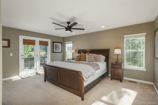 bedroom with access to outside, light carpet, multiple windows, and ceiling fan