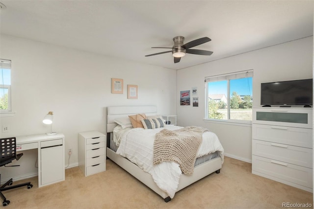 bedroom featuring light carpet, multiple windows, and ceiling fan