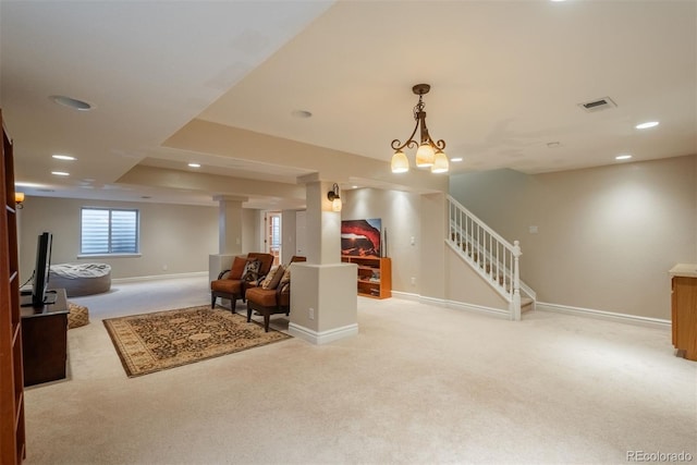 interior space featuring light colored carpet, a chandelier, and decorative columns