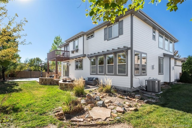 rear view of property featuring a yard, an outdoor living space, a balcony, a patio area, and central air condition unit