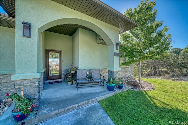 doorway to property featuring a lawn and a porch