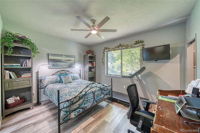 bedroom featuring a textured ceiling, light hardwood / wood-style floors, and ceiling fan