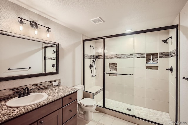 bathroom featuring tasteful backsplash, tile patterned floors, a shower with door, vanity, and a textured ceiling