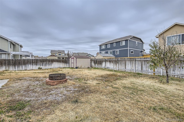 view of yard with a shed, a water view, and an outdoor fire pit